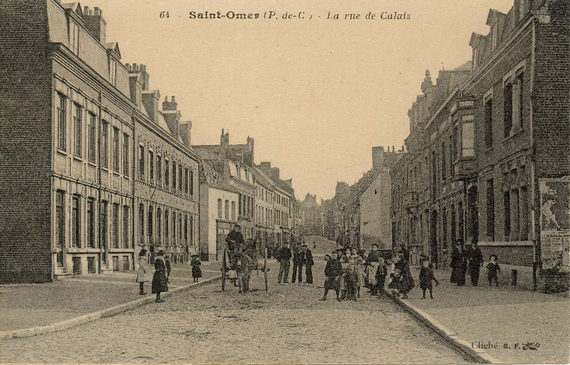 Une vue de la rue trés annimée,beaucoup d'enfants et une charrette tirée par un âne. C'est par cette rue que Louix XIV entra dans St Omer en 1677, lorsque la ville fut rattachée à son royaume.